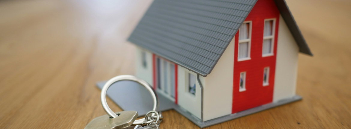 white and red wooden house miniature on brown table